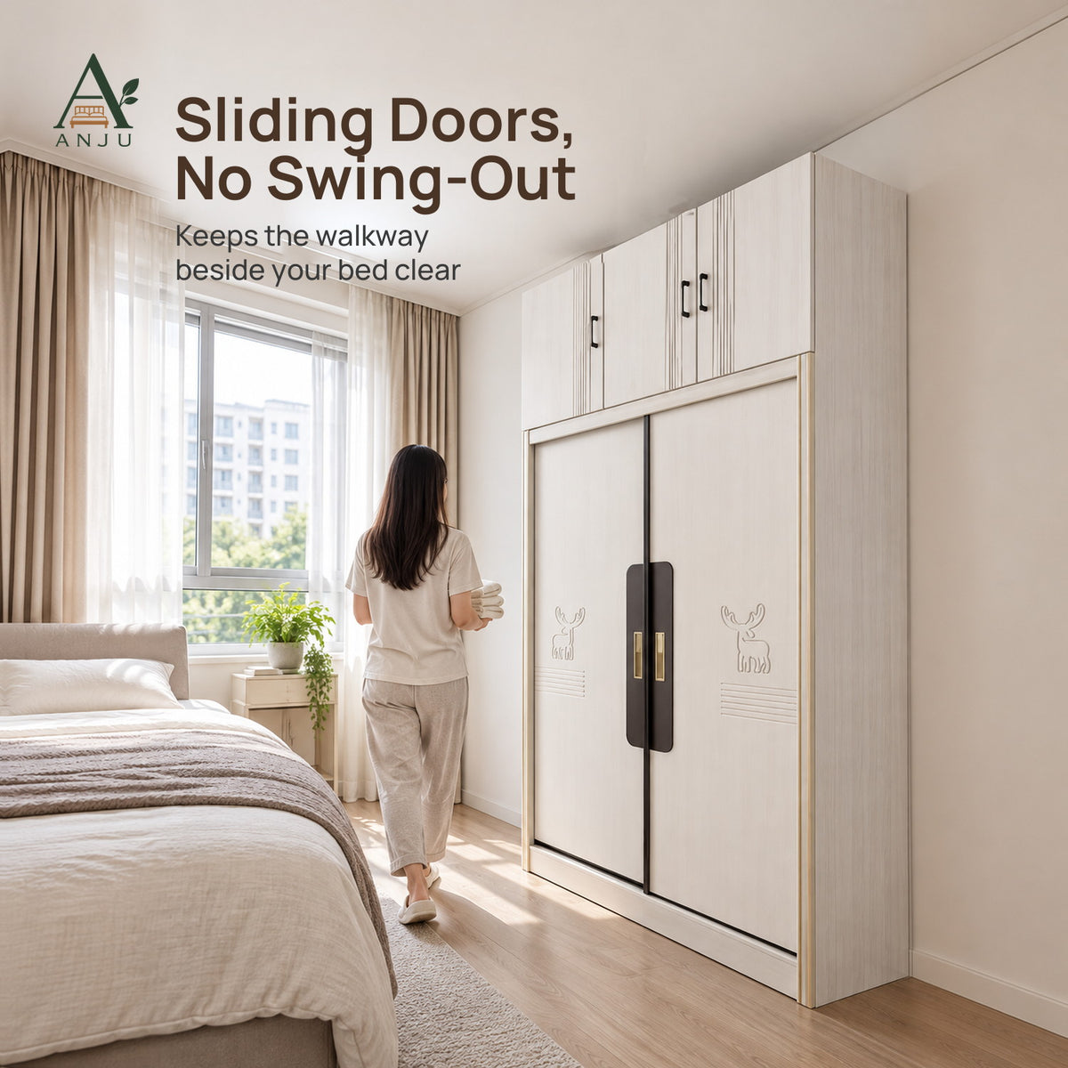 Woman walking past a white 2-door sliding wardrobe with top cabinets, beside a bed in a bright bedroom