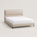 ANJU low profile bed frame with beige padded headboard, shown with a mattress, three-quarter view on plain background